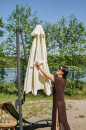 woman_fastening_the_velcro_strap__of_a_folded_beige_garden_umbrella_2d6e.product_gallery.jpg