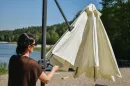 woman_unfolding_beige_umbrella_with_side_pole_699f.webp